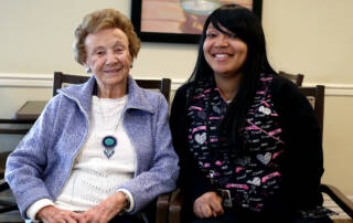 Personal care resident and aid smiling together